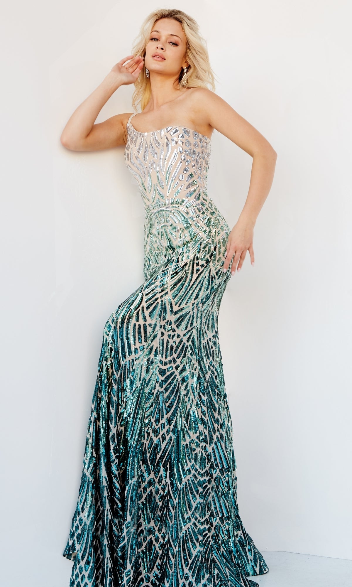 A woman poses against a plain white background wearing the Jovani 06469 Ombre Sequin-Print Prom Gown, a strapless, fitted mermaid dress with green and silver sequin patterns.